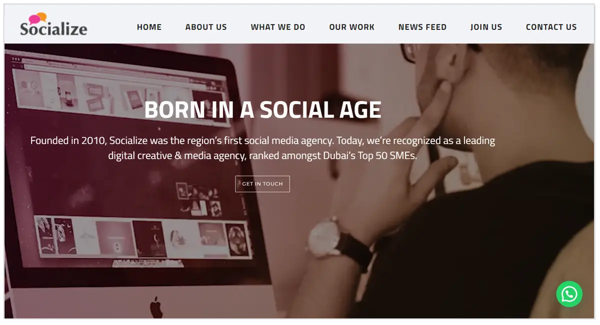 Home page of Socialize with a picture of man working on the Laptop with Get in Touch button.