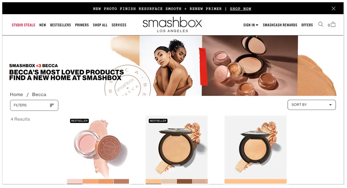 A home page of Becca cosmetics with its beauty products and two girl models hugging each other.